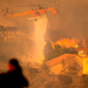 A helicopter drops water to help fight flames as the Saddleridge Fire in the Porter Ranch section of Los Angeles, California on October 11, 2019.